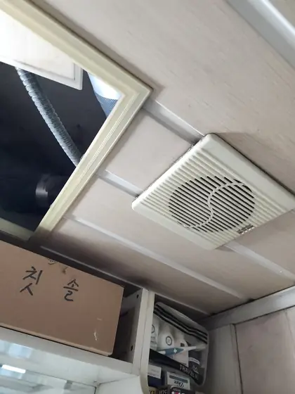 환풍기 고장 수리 — 천장에 낡은 흰 환풍기가 붙어 있는 모습