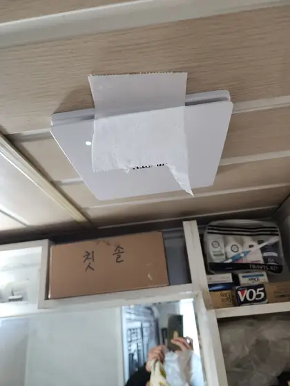 환풍기 고장 수리 — 휴지를 대고 흡입을 확인하는 모습